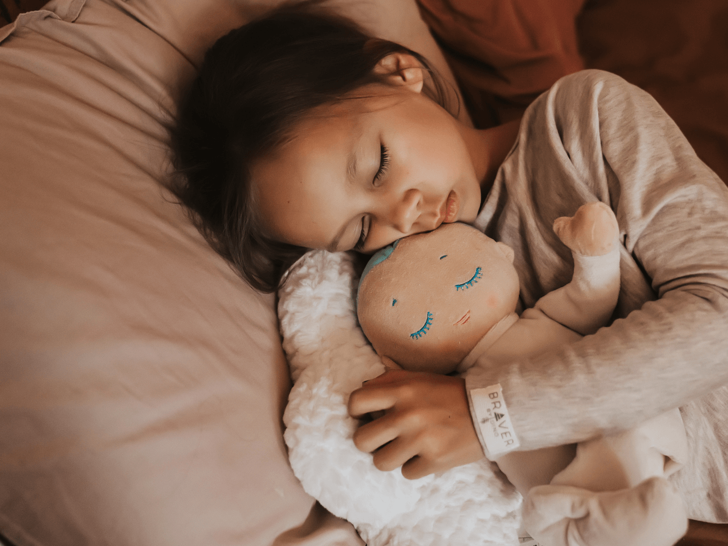 Niña durmiendo placidmanete con un muñeco que le ayuda a dormir profundamente durante toda la noche. Lulla doll es un peluche para dormir abrazado. 